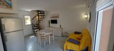a living room with a yellow couch and a table at Residence Riviera in Porto-Vecchio