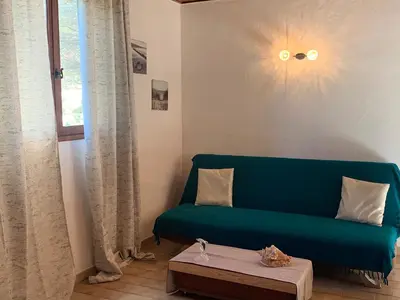 a living room with a green couch and a table at Gîte à Poggiale de Figari in Figari