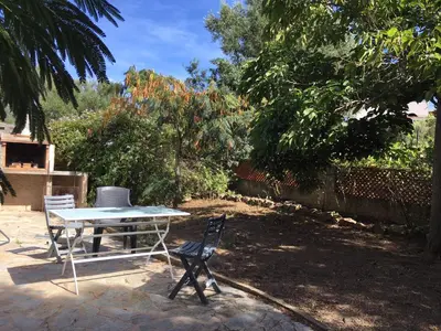 a table and two chairs in a yard at Gîte à Poggiale de Figari in Figari