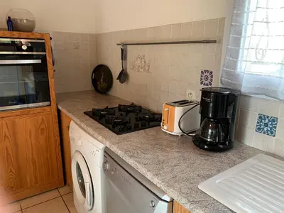 a kitchen with a stove top oven next to a microwave at Gîte à Poggiale de Figari in Figari