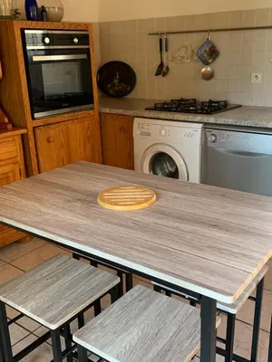 a kitchen with a wooden table and two chairs at Gîte à Poggiale de Figari in Figari