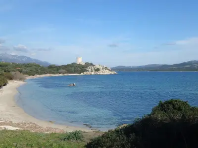 a view of a beach with a castle in the distance at Gîte à Poggiale de Figari in Figari