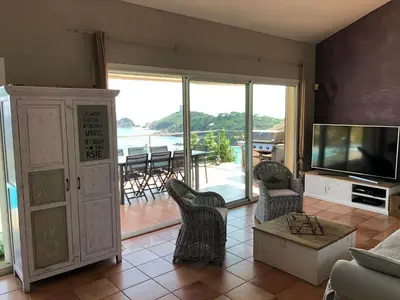 a living room with a television and a table and chairs at Villa Rosa in Conca