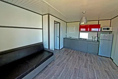a kitchen with a couch in the middle of a room at Camping Torraccia in Cargèse