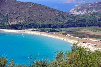 a beach in the middle of a body of water at Camping Torraccia in Cargèse