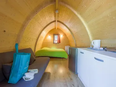 a room with a couch and a bed in a tunnel at Camping Torraccia in Cargèse