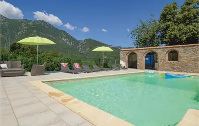 an outdoor swimming pool with chairs and umbrellas at Awesome Home In Santa Maria Poggio in Santa-Maria-Poggio