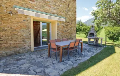 a patio with a table and chairs and a fireplace at Awesome Home In Santa Maria Poggio in Santa-Maria-Poggio