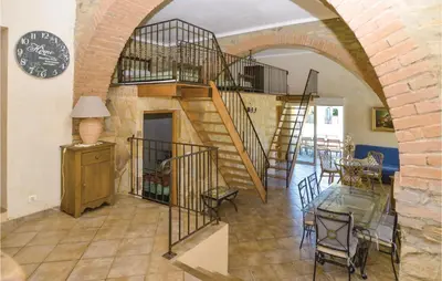 a living room with a spiral staircase and a table at Awesome Home In Santa Maria Poggio in Santa-Maria-Poggio