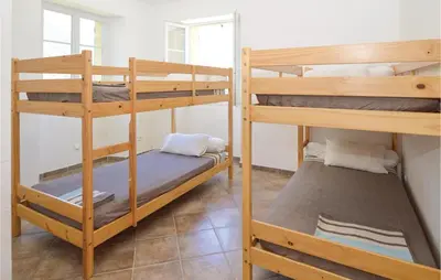 a room with three bunk beds in a hostel at Awesome Home In Santa Maria Poggio in Santa-Maria-Poggio