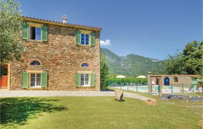 a stone house with a pig standing in the grass at Amazing Home In Santa Maria Poggio in Santa-Maria-Poggio