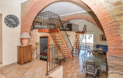 a living room with a spiral staircase in a brick wall at Amazing Home In Santa Maria Poggio in Santa-Maria-Poggio