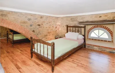 a bedroom with a bed and a brick wall at Amazing Home In Santa Maria Poggio in Santa-Maria-Poggio