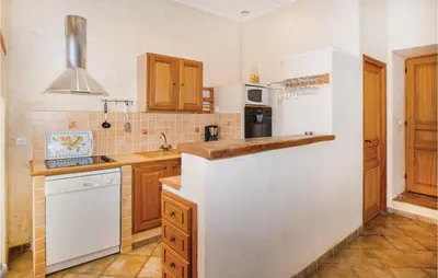 a kitchen with wooden cabinets and a white refrigerator at Amazing Home In Santa Maria Poggio in Santa-Maria-Poggio