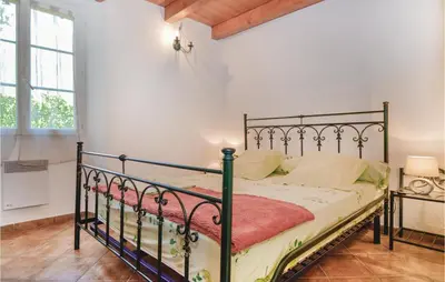 a bedroom with a metal bed in a room at Amazing Home In Santa Maria Poggio in Santa-Maria-Poggio