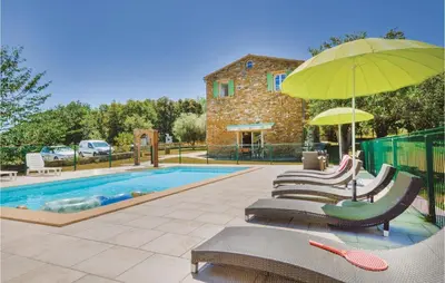 a group of chairs with an umbrella next to a pool at Amazing Home In Santa Maria Poggio in Santa-Maria-Poggio