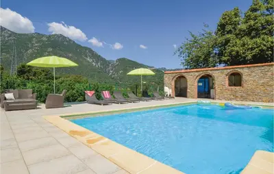 a swimming pool with chairs and umbrellas next to a house at Beautiful Home In Santa Maria Poggio in Santa-Maria-Poggio