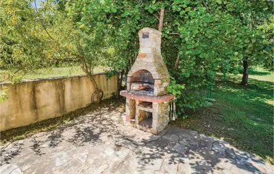 a brick oven in a garden next to a wall at Beautiful Home In Santa Maria Poggio in Santa-Maria-Poggio