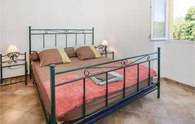 a bedroom with a bed with a metal frame at Beautiful Home In Santa Maria Poggio in Santa-Maria-Poggio