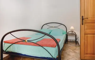 a bedroom with a bed with blue pillows at Beautiful Home In Santa Maria Poggio in Santa-Maria-Poggio