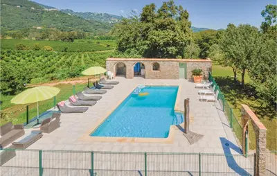 an external view of a pool with chairs and umbrellas at Beautiful Home In Santa Maria Poggio in Santa-Maria-Poggio