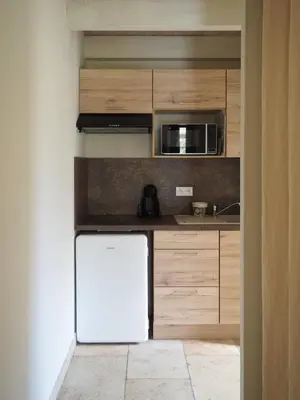a kitchen with a white refrigerator and a microwave at Songes d’été in Bonifacio