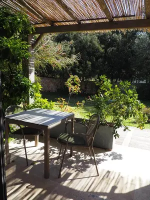 a table and chairs sitting under a pergola at Songes d’été in Bonifacio