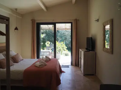 a bedroom with a bed and a sliding glass door at Songes d’été in Bonifacio