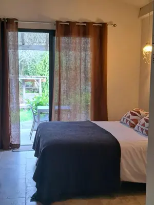 a bedroom with a bed and a large window at Songes d’été in Bonifacio