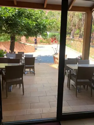 a view of a patio with tables and chairs at Hotel Corsica - Porto Corse in Porto Ota