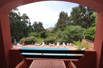 a view of a swimming pool from a window at Hotel Corsica - Porto Corse in Porto Ota