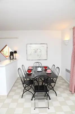 a table and chairs on a balcony with a view of the ocean at Residenza l 'Alivetu in Cargèse