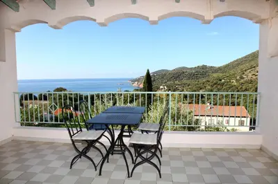 a small kitchen with a table and a refrigerator at Residenza l 'Alivetu in Cargèse