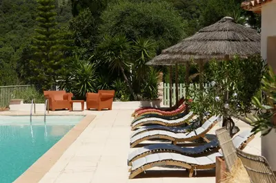 a group of lounge chairs next to a swimming pool at Residenza l 'Alivetu in Cargèse