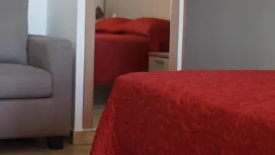 a bedroom with a red bed and a chair at L'Allegria in Casaglione