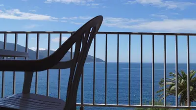a chair on a balcony overlooking the ocean at L'Allegria in Casaglione
