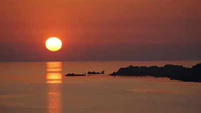 a sunset over the ocean with the sun setting at L'Allegria in Casaglione