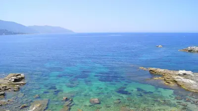 a large body of water with rocks and blue water at L'Allegria in Casaglione