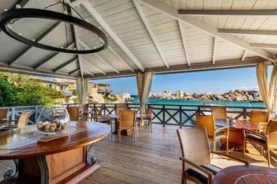 a patio with a table and chairs and the ocean at Hotel & SPA des Pecheurs in Bonifacio