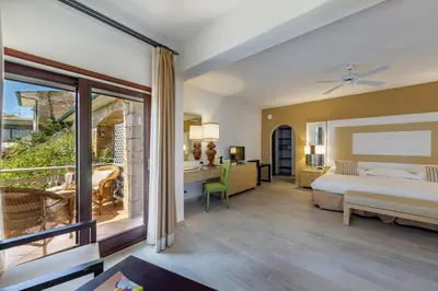 a bedroom with a bed and a balcony at Hotel & SPA des Pecheurs in Bonifacio
