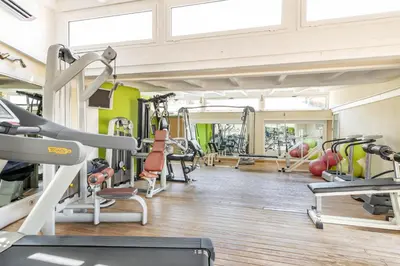 a gym with a lot of treadmills and machines at Hotel & SPA des Pecheurs in Bonifacio