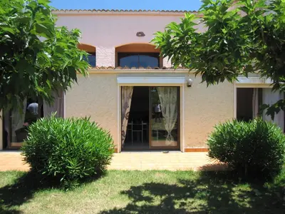 a house with a front door and two bushes at Residence les Bell'ombres in Cargèse
