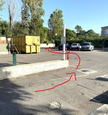 a red hose is tied to a pole in a parking lot at Sables de biguglia cordon lagunaire in Borgo
