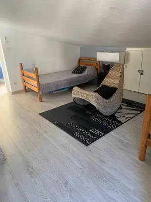 a room with a bed and two chairs and a rug at Sables de biguglia cordon lagunaire in Borgo