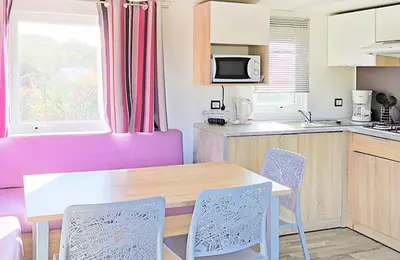 a kitchen with a table and chairs in a room at Camping Kévano Plage in Pianottoli-Caldarello