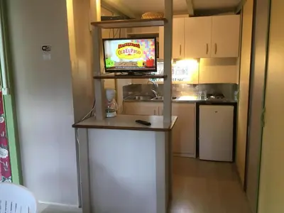 a kitchen with a counter with a television on it at Camping du Soleil in Appietto