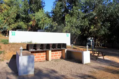 a building with a bench in a park at Camping du Soleil in Appietto