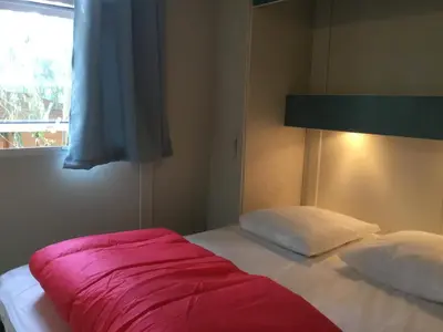 a bedroom with a bed with a red blanket on it at Camping du Soleil in Appietto