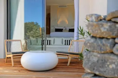 a room with two chairs and a table and a bed at Hôtel Cala di Greco in Bonifacio