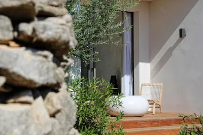 a white vase sitting on a porch with a chair at Hôtel Cala di Greco in Bonifacio